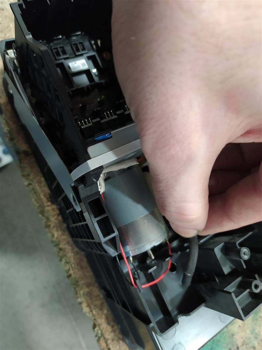 Interior de una Epson doméstica con la carcasa quitada: mecanismo de transporte de papel, carro del cabezal en posición home y bomba de limpieza visible al fondo