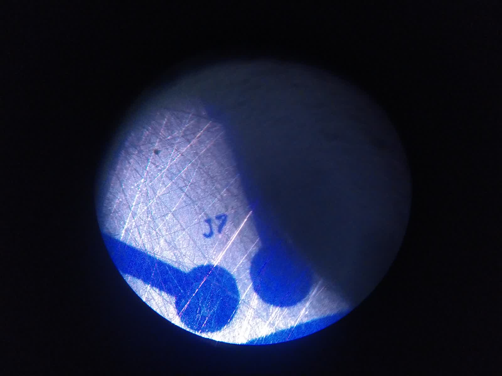 Vista al microscopio de la película fotosensible china mostrando la superficie y zonas donde el material empieza a despegarse