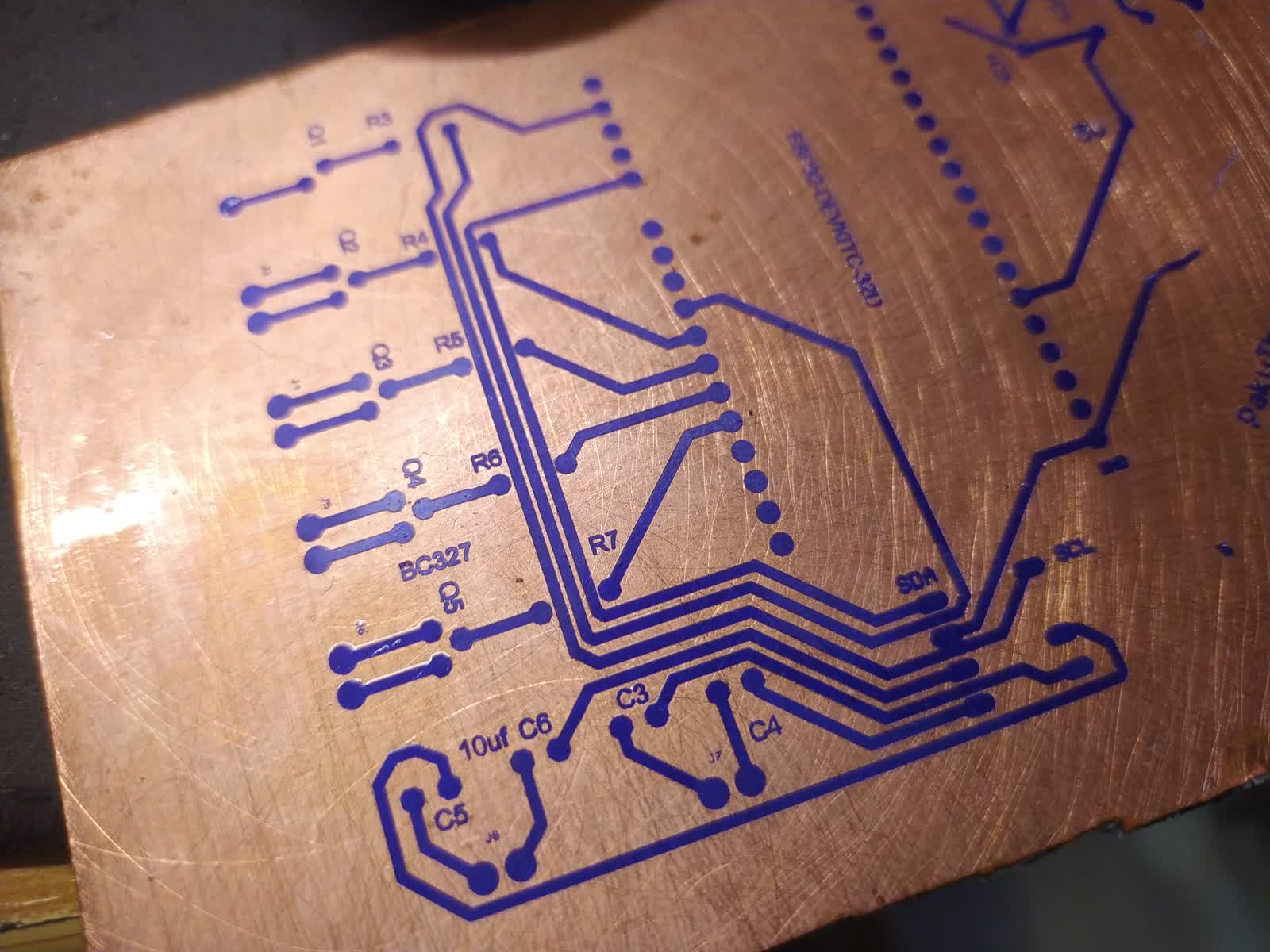 Detalle de la placa con película fotosensible china revelada mostrando los trazados azules sobre cobre