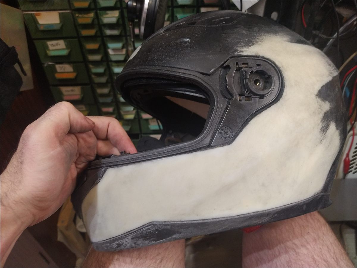 Pintar casco de moto: lijado en progreso, zona ya lijada en blanco junto a zona sin lijar en negro